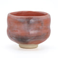 Aka-Raku Chawan - front view of the red raku matcha bowl with black patches