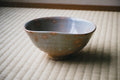 Ceramic bowl with speckled pattern on a textured surface
