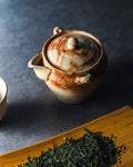 Hidasuki Tokoname-yaki handleless teapot (houhin) - styled view with loose tea leaves