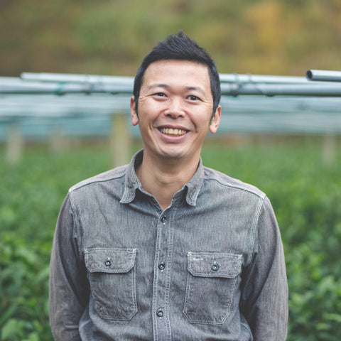 Masahiro Kuma standing in front of the Kumaen tea fields