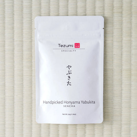 White Tezumi pouch of Handpicked Honyama Yabukita Sencha (やぶきた) on a tatami mat.