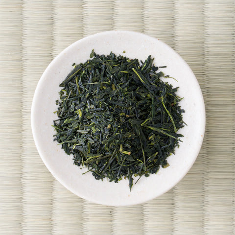 Overhead view of Haru-Sora sencha leaf, dark green with pale stems, on a small white dish