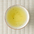 Haru-Sora sencha brewed to a pale yellow-green liquor in a speckled white cup, viewed from above