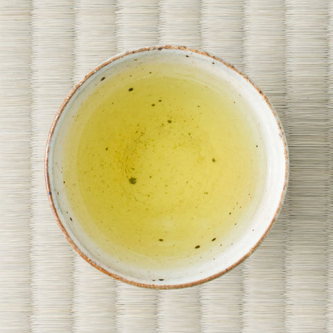 Haru-Sora sencha brewed to a pale yellow-green liquor in a speckled white cup, viewed from above