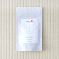 White Tezumi Specialty pouch labelled こうしゅん / Honyama Koushun Wakoucha, lying flat on a tatami mat