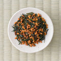 Loose Koshihikari genmaicha on a white dish, dark green leaf mixed with toasted puffed rice