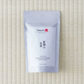 White Tezumi Specialty pouch marked 夏摘み在来 / Kumamoto Zairai Wakoucha, Second Flush, lying flat on a tatami mat