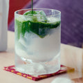 Iced matcha latte in a tall glass, a stream of dark green matcha pouring over ice and milk.