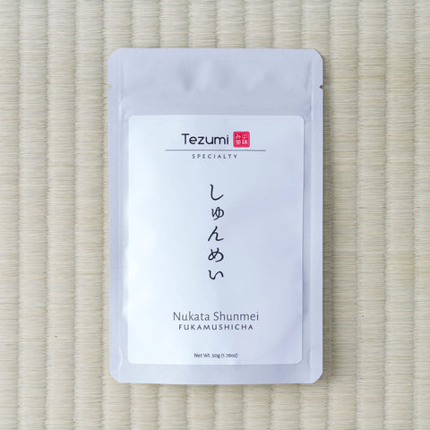 Silver Tezumi pouch of Nukata Shunmei Fukamushicha (しゅんめい) on a tatami mat.