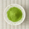 Vivid green Rikyu matcha powder in a small cream dish, viewed from above.