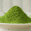 Vivid green Rikyu matcha powder mounded in a ceramic bowl, side view.