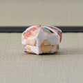 Blush and gold floral brocade silk kogo photographed from the side on tatami, its lid resting slightly askew on the body