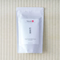 Silver Tezumi pouch of Takachiho Benifuki Oolong (紅富貴) on a tatami mat.