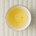 Golden Takachiho Unkai oolong brewed in a ceramic cup, viewed from above on tatami.