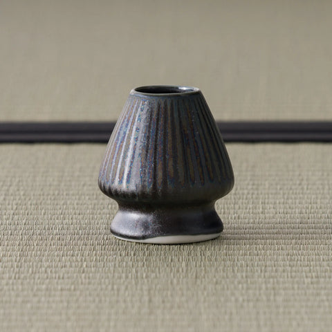 Three-quarter view of the bronze-glazed kusenaoshi showing its ribbed, tapering form