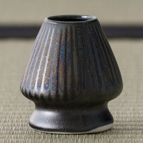 Side view of the dark fluted kusenaoshi whisk stand on tatami