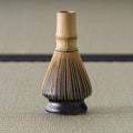The kusenaoshi shown in use with a bamboo matcha whisk (chasen) resting on it