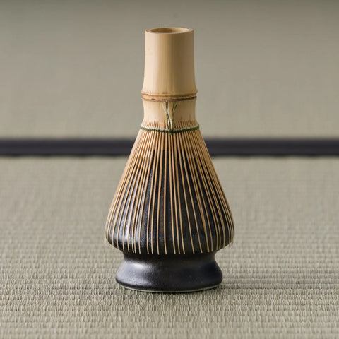 The kusenaoshi shown in use with a bamboo matcha whisk (chasen) resting on it