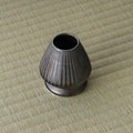 Dark glazed ceramic kusenaoshi whisk-shaper seen from above showing its rounded opening