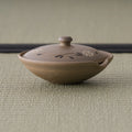 Beige shiboridashi seen from the front showing its low, wide form and knobbed lid