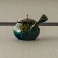 Side view of the green kyusu showing the gold floral decoration across the body