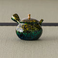 Green-and-gold kyusu teapot, three-quarter view with the side handle and spout to the right
