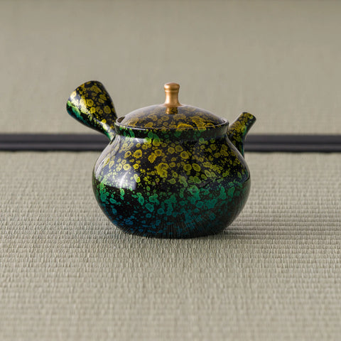 Green-and-gold kyusu teapot, three-quarter view with the side handle and spout to the right