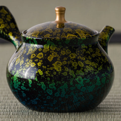 Close-up of the kyusu body showing the dense gold blossoms over the deep green glaze