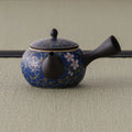 Floral blue-and-gold kyusu teapot, three-quarter view with the spout to the right