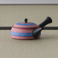 Side view of the pink kyusu showing the dark spout and blue decorative bands