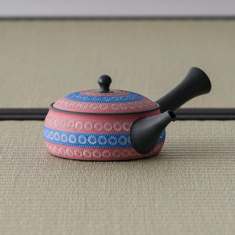 Side view of the pink kyusu showing the dark spout and blue decorative bands
