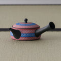 Reddish-pink shudei side-handle kyusu with blue inlaid ring-pattern bands, spout to the left on tatami