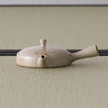 Opposite-side view of the flat beige kyusu with the spout to the left
