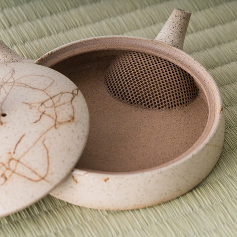 Close-up of the flat kyusu with the lid set ajar, showing the interior