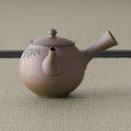 Grey-brown kyusu teapot, three-quarter view with the spout to the right
