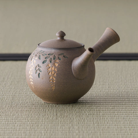 Side view of the kyusu showing the hollow side handle and engraved floral motif