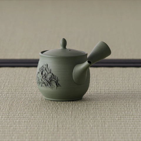 Sage-green celadon side-handle kyusu with carved decoration, spout to the left on tatami