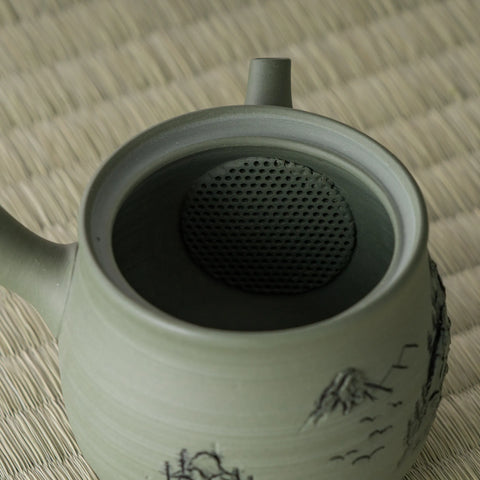 Close-up into the green kyusu interior showing the built-in mesh strainer