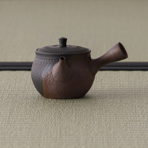 Brown carved-texture kyusu teapot, three-quarter view with the spout to the right