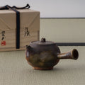 Wood-fired tokoname side-handle kyusu in earthy brown tones shown with its wooden storage box, spout to the right