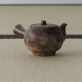 Brown wood-fired kyusu with the spout angled to the left