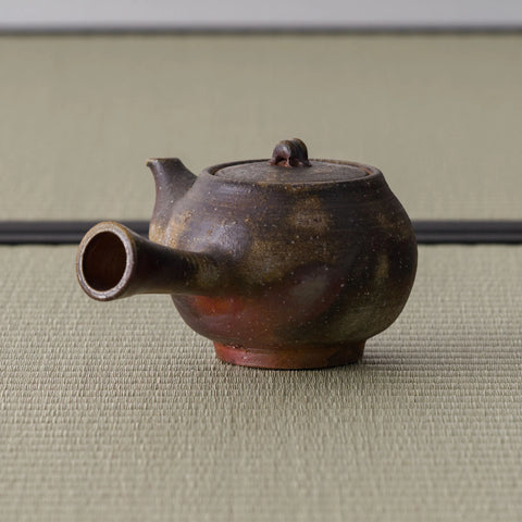 Close view of the kyusu's spout opening and rounded wood-fired body