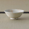 Cream-white glazed shallow bowl, side profile on a tatami mat.