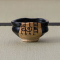 Kutsu-gata Kuro-Oribe chawan with abstract dark brushwork painted on a crackled bare clay panel.