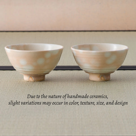 Two spotted peach-toned chawan side by side, with a note that handmade ceramics vary in color, texture, size, and design.