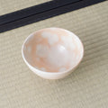 Overhead view into a peach and white spotted chawan showing its smooth glazed interior.