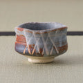 Back of a grey and rust Shino-glazed chawan showing an incised crosshatch design.