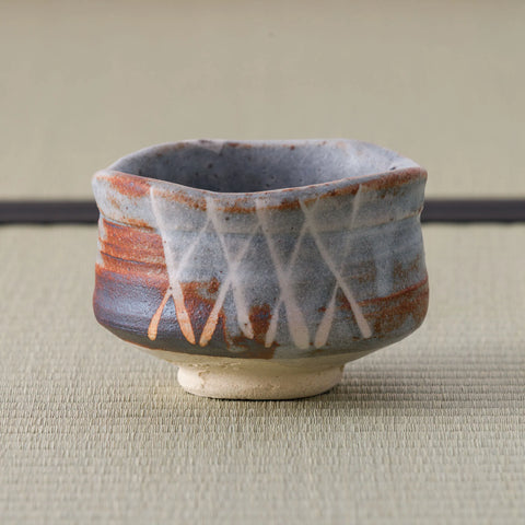Back of a grey and rust Shino-glazed chawan showing an incised crosshatch design.