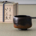Kuro-raku black raku matcha bowl shown beside its signed wooden box