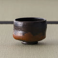 Kuro-raku black raku matcha bowl, three-quarter view of the waisted black bowl